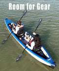 Two people paddling the Razorlite 473rl Inflatable Drop Stitch Kayak Pro Package on a lake, showing tandem seating and gear space.