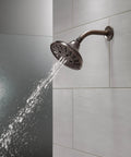 Five Setting Raincan Shower Head With H2Okinetic Spray in Venetian Bronze displaying water flow on tiled wall