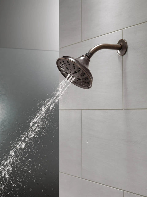 Five Setting Raincan Shower Head With H2Okinetic Spray in Venetian Bronze displaying water flow on tiled wall