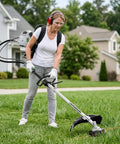 Person using 6 In 1 Backpack Gas Powered Weed Eater Kit With 52cc 2 Stroke Engine Includes String Trimmer Hedge Trimmer Pole Saw Brush Cutter Blade And Safety Lock Shoulder Strap For Lawn Trimming on grass.