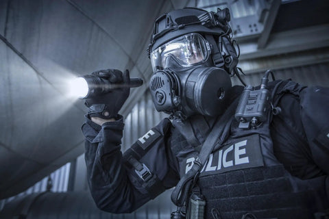 Officer holding ProTac HL 5-X 3500 Lumen Multi Fuel Tactical Flashlight With Rechargeable Batteries And USB in a dark setting.