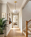 Vaziden Milk Glass Pendant Lights Kitchen Island Gold Chandelier 11.81" hanging in a modern hallway with plants and decor.