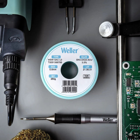 Weller solder wire spool alongside soldering tools and PCB