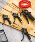 Heavy Duty 4 Piece Air Blow Gun Kit With Angled Aluminum Nozzles And Slick Pistol Grip To Blast Off Dust And Chips Fast For Auto Detailing Crew Or Local Shop on a wooden surface.