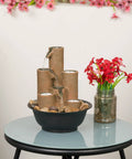 Indoor Tabletop Tiered Water Fountain With 3 Candles, 11 Inch Brown on round glass table with flowers and rocks