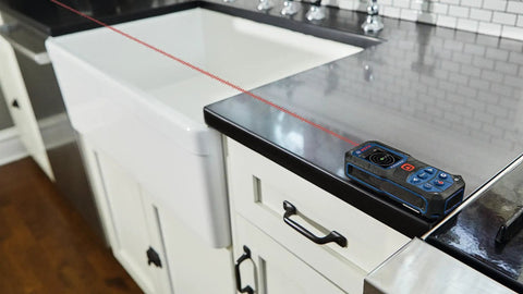 Super Handy 165 Foot Blaze Laser Distance Measure With Backlit Color Display on kitchen counter measuring distance
