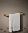 Honesty 18 Inch Towel Bar In Vibrant Brushed Moderne Brass, Modern Bath Hardware With Solid Metal Construction, holding a white towel