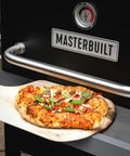 Gravity Series Outdoor Pizza Oven Accessory Insert With Ceramic Stone And Stainless Interior, pizza on wooden paddle