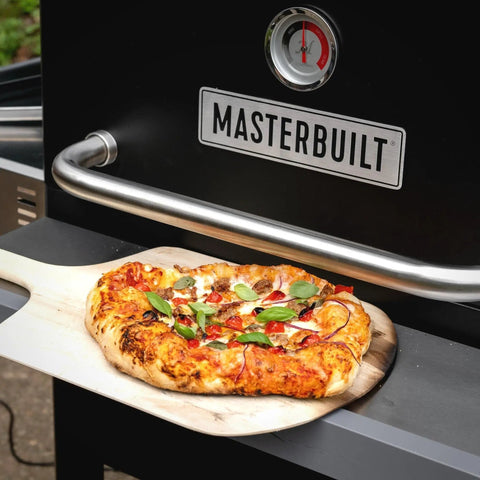 Gravity Series Outdoor Pizza Oven Accessory Insert With Ceramic Stone And Stainless Interior, pizza on wooden paddle