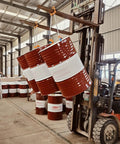 Heavy Duty Drum Lifter Clamp For Forklifts And Job Site Cranes Featuring Carbon Steel Chain lifting three barrels in warehouse.