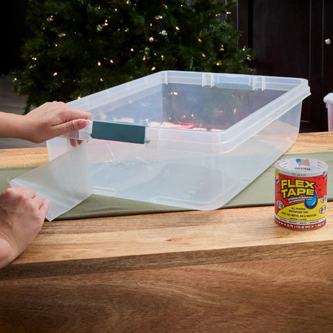 Person applying Thick Rubberized Waterproof Tape That Patches And Seals Leaks Like A Pro Anywhere Underwater Ready Indoor Outdoor Use Great For Roofs Plumbing Pools And RVs Clear 4 In By 5 Ft Pack Of 1 to a clear plastic container.