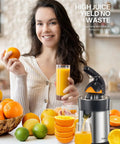 Electric Citrus Juicer With Brushed Stainless Steel Finish in use, extracting juice from fresh oranges, showcasing dual-size cups.