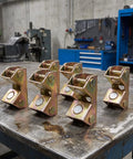 Six Pack Magnetic Welding Clamps With V-Shape Stainless Steel Fixture Set arranged on a metal table in a workshop.