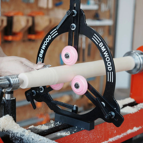 BMWOOD woodturning steady rest MC-FS7 mounted on a lathe; black metal frame with pink roller wheels