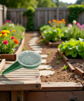 Adjustable Seed Dispenser Hand Tool for Garden Planting and Sowing on raised garden bed, surrounded by flowers and vegetables.