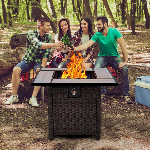 30 Inch Wicker Patio Fire Pit Table With Fire Glass For Outdoor Parties And Gatherings surrounded by friends in a forest setting