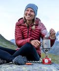 Camper enjoying a meal in the mountains with the Ultralight Titanium Spork For Backpacking And Camping Doubles As Spoon And Fork With Carabiner Loop Durable Camping Utensil For Outdoor Meals That You Can Rely On At The Campfire.