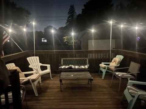 Ambience Pro 48 Ft Solar Outdoor String Lights With 15 Shatterproof 1W LEDs illuminating a cozy patio deck at night
