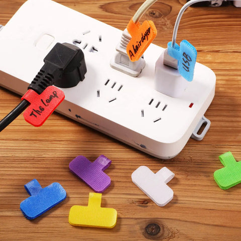 Colorful writable tags from 48 Piece Cable Labels And Ties Cord Organizer Kit for home office on power strip.