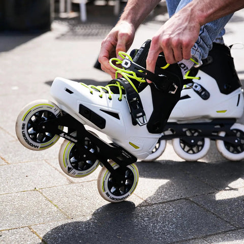 Person adjusting Lightning 110 Inline Skates For Men With 3x110 Wheel Setup, Urban City Cruising And Fitness Skating, White And Black