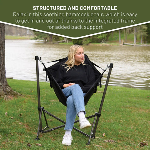 Person sitting in Portable Hammock Camping Chair With Stand by a lake, stainless steel frame, outdoor setting