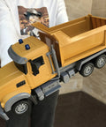 Child holding Remote Control Dump Truck Toy For Kids With 6 Channel Radio Control And Bright LED Lights Totally Cool Realistic RC Construction Vehicle