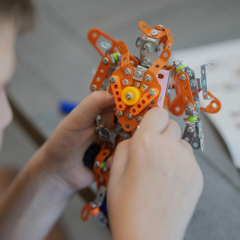 Rugged Metal Erector Set Build Kit For Adults And Teens, 389-Piece STEM Toy To Build A Robot Or Excavator, Dope Educational Engineering Craft For Advanced Kids And Hobbyists; hands holding metal robot build