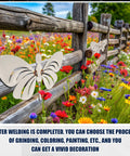 Butterfly Welding Practice Kit 8 Pcs Coupons For Beginners And Pros mounted on wooden fence in field of colorful wildflowers.
