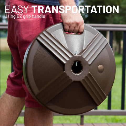 Man carrying the Fillable Bronze Patio Table Umbrella Base Built To Last And Heavy Duty With 3 Point 5 Pound Weight Fits One To One
