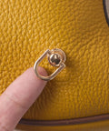 Close-up of 4 Pcs Dope Gold D Rings For Purses Rotatable 360 Degree Metal Hardware With Studs on yellow leather surface