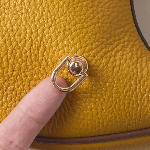 Close-up of 4 Pcs Dope Gold D Rings For Purses Rotatable 360 Degree Metal Hardware With Studs on yellow leather surface