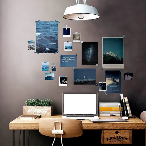 Desk with mixed media art from 114 Piece Aesthetic Scrapbook Kit For DIY Junk Journaling Supplies featuring posters and cards.