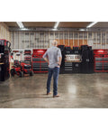 Man in a workshop standing before heavy duty plastic tool box with drawers and stackable organizer system