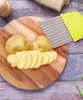 Crinkle cutter knife with yellow handle and stainless steel wavy blades for slicing potatoes into fries