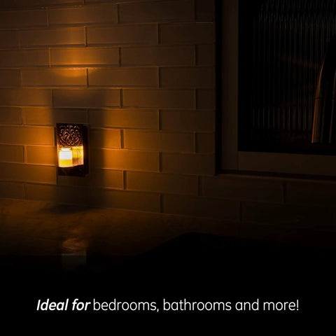 Decorative LED Night Light with Plug-In Dusk-To-Dawn Sensor in Warm White Brushed Nickel Finish for Living Room Bedroom Nursery Kitchen or Bathroom, glowing softly on tiled wall.