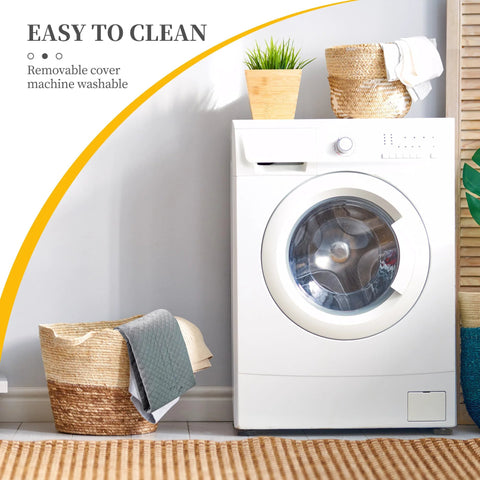 Front view of a white front-loading washing machine in a laundry room with wicker basket, towels, and a potted plant.