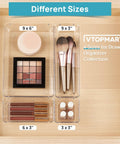 Level Up Your Vanity Game With This 10 Piece Clear Drawer Organizer Set showing different sizes of trays with cosmetics and brushes.