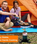Portable Propane Camping Stove With Foldable Gas Tank Base Adjustable Flame Backpacking Cooker in front of orange tent