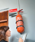 High Visibility Fire Extinguisher Sticker Set for Office and Commercial Spaces No Brainer Safety Sign for Landlords and Short Term Rentals 6x2 Inches Includes Four Labels for Quick Access and Compliance installed above extinguisher on wall.