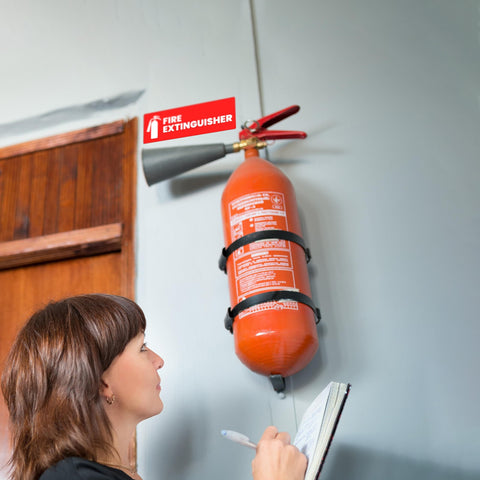 High Visibility Fire Extinguisher Sticker Set for Office and Commercial Spaces No Brainer Safety Sign for Landlords and Short Term Rentals 6x2 Inches Includes Four Labels for Quick Access and Compliance installed above extinguisher on wall.