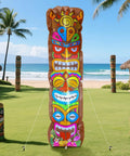 5 Ft Inflatable Tiki Decoration For Outdoor Luau Party With Built In LED Lights Flamingo And Palm Trees Blow Up Tiki Totem Yard Decor For Summer Beach Parties And Poolside Vibes Hawaiian Aloha Celebration Ready standing on grass with ocean backdrop