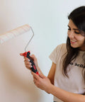 Woman holding paint roller from Eight Piece Painting Roller Kit With Tray And Brushes, Pro Grade Decorating Tools For Home DIY Projects.