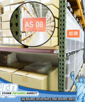 Heavy Duty Warehouse Aisle Sign Holders For Pallet Rack Upright With Flexible Hinge 50 Pack visible on a rack in a warehouse.