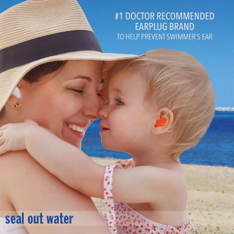 Mack's Pillow Soft silicone earplugs, orange, worn by child at the beach