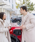 Couple speaking beside red electric car plugged into Tesla NACS Level 2 EV Charger with 48 Amp Fast Charge 11.5kW Wall Mount EVSE