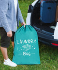 Person holding one of Two Pack Extra Large Travel Laundry Bags For Dirty Clothes next to an open car trunk, showing drawstring closure.