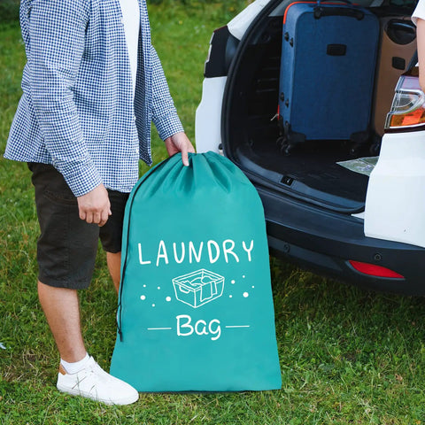 Person holding one of Two Pack Extra Large Travel Laundry Bags For Dirty Clothes next to an open car trunk, showing drawstring closure.