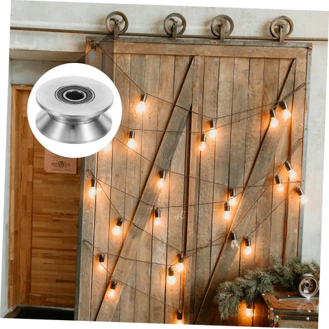 Heavy Duty Stainless Steel Sliding Door Rollers U Groove Caster Wheels on a wooden barn door with string lights background.