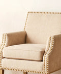 Twenty Piece Pack Of Solid Brass Upholstery Tacks With Top Shelf Hold And A Sweet Vintage Look For Furniture Projects Smooth Woodcraft Crafts And Easy Diy Home Decor Fixes In Classic Gold Finish And One Half Inch Heads on a beige armchair.