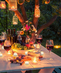 Outdoor table setup with wine, cheese, and 24 Pack Battery Operated Tea Lights Candles With Realistic LED Flicker for party decor.
